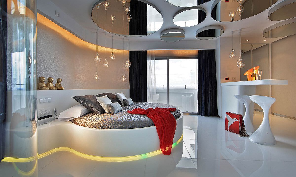 تخت خواب گرد دو نفره سفید رنگ که به اتاق لوکس و مدرن، جلوه ای منحصر به فرد و جذاب داده است